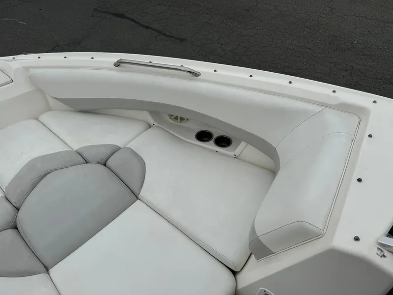 Slide: The Image of 2006 Larson LXi 248 boat interior with white seating and table, American flag visible. - 14