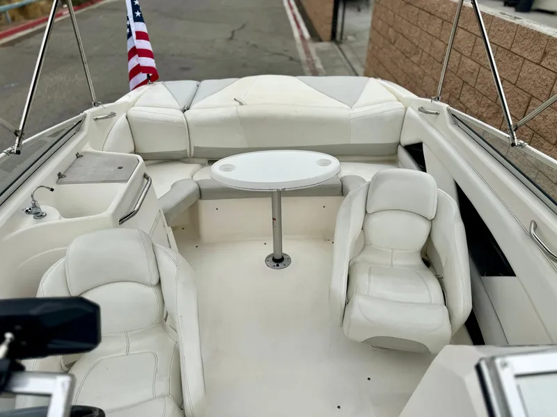 Slide: The Image of 2006 Larson LXi 248 boat interior with white seating and dashboard. - 15