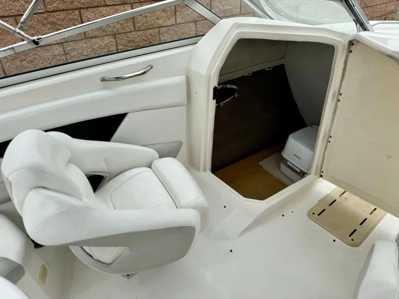 Slide: The Image of 2006 Larson LXi 248 boat cabin with portable toilet and storage space. - 17