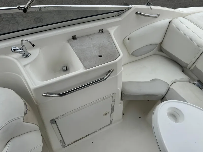 Slide: The Image of 2006 Larson LXi 248 boat interior with open storage compartment and sink. - 19