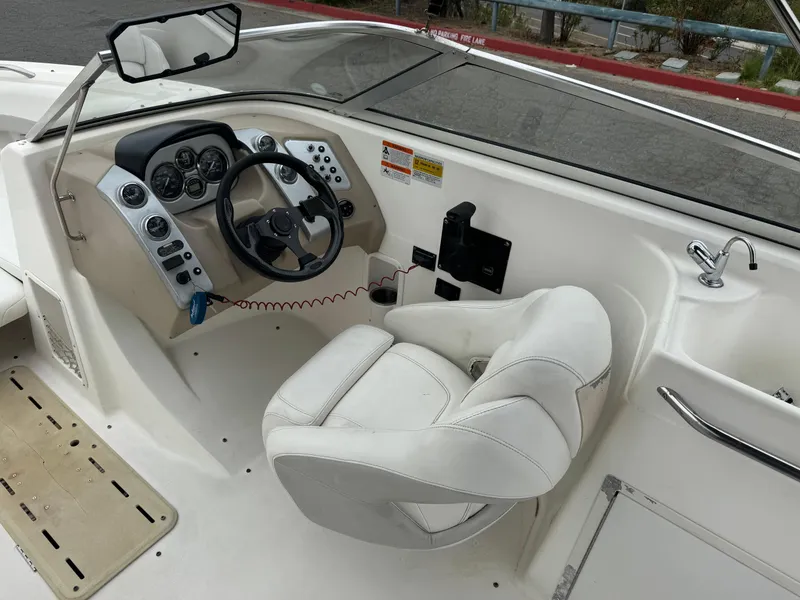 Slide: The Image of 2006 Larson LXi 248 boat cockpit with steering wheel and control panel. - 22