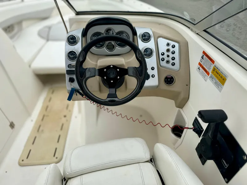 Slide: The Image of 2006 Larson LXi 248 boat dashboard with gauges and controls. - 23