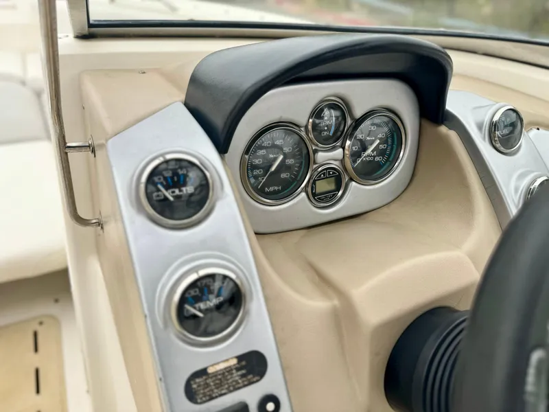 Slide: The Image of 2006 Larson LXi 248 boat dashboard with steering wheel and gauges. - 24