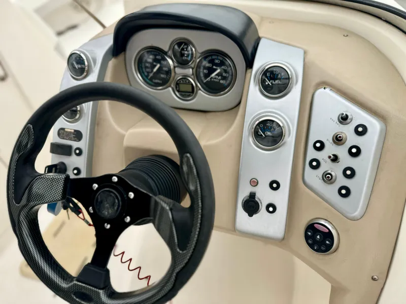 Slide: The Image of 2006 Larson LXi 248 boat interior with white seating and table. - 25