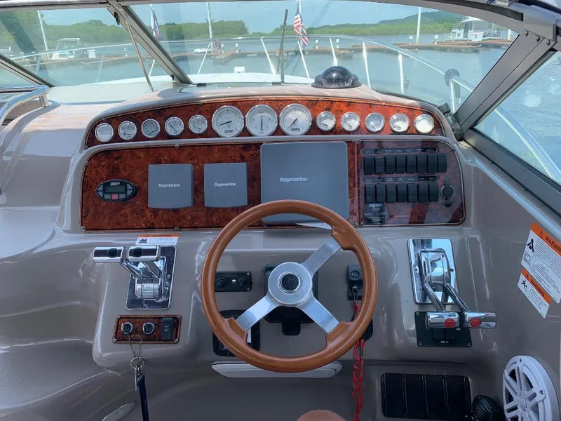 Slide: The Image of 2004 Larson Cabrio 370 boat dashboard with steering wheel and control panel. - 10