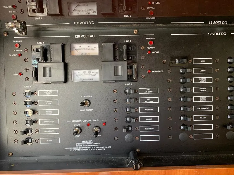 Slide: The Image of Electrical control panel of a 2004 Larson Cabrio 370 boat, featuring switches and meters. - 12