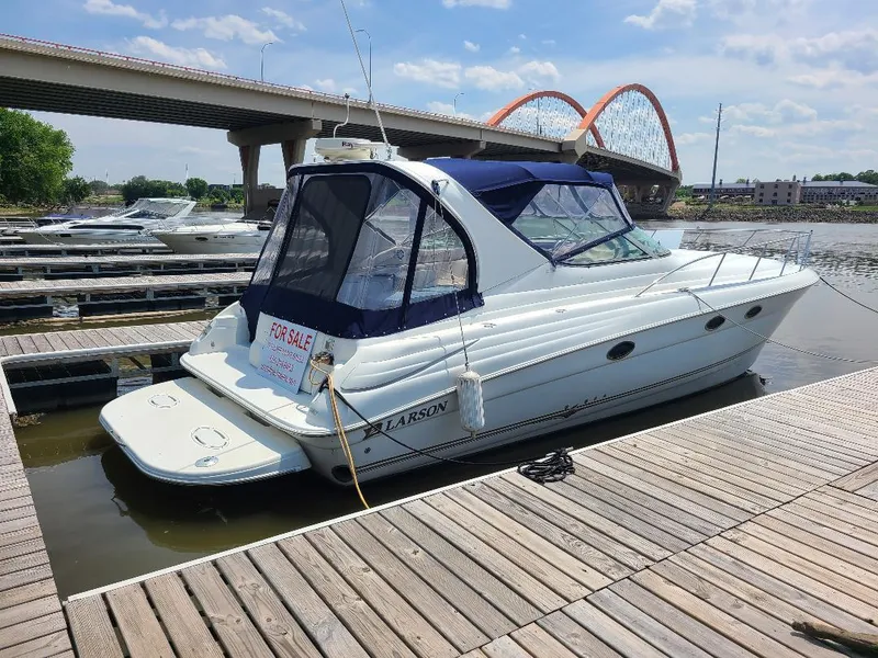 Slide: The Image of 2004 Larson Cabrio 370 boat docked, for sale, with bridge and blue sky background. - 13
