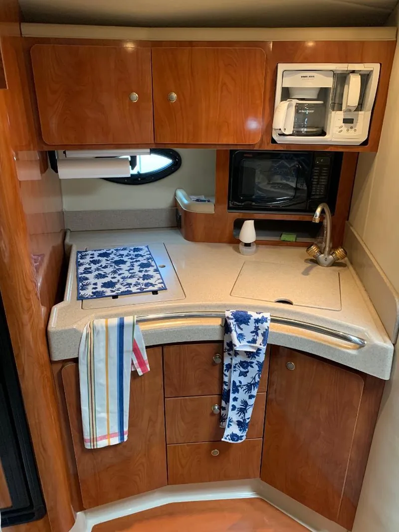 Slide: The Image of 2004 Larson Cabrio 370 boat kitchen with wood cabinets, sink, and microwave. - 4