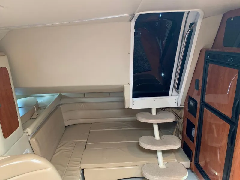 Slide: The Image of 2004 Larson Cabrio 370 interior with beige seating and wooden cabinetry. - 5