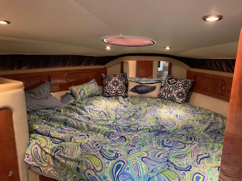 Slide: The Image of 2004 Larson Cabrio 370 cabin with colorful bedding and decorative pillows. - 9