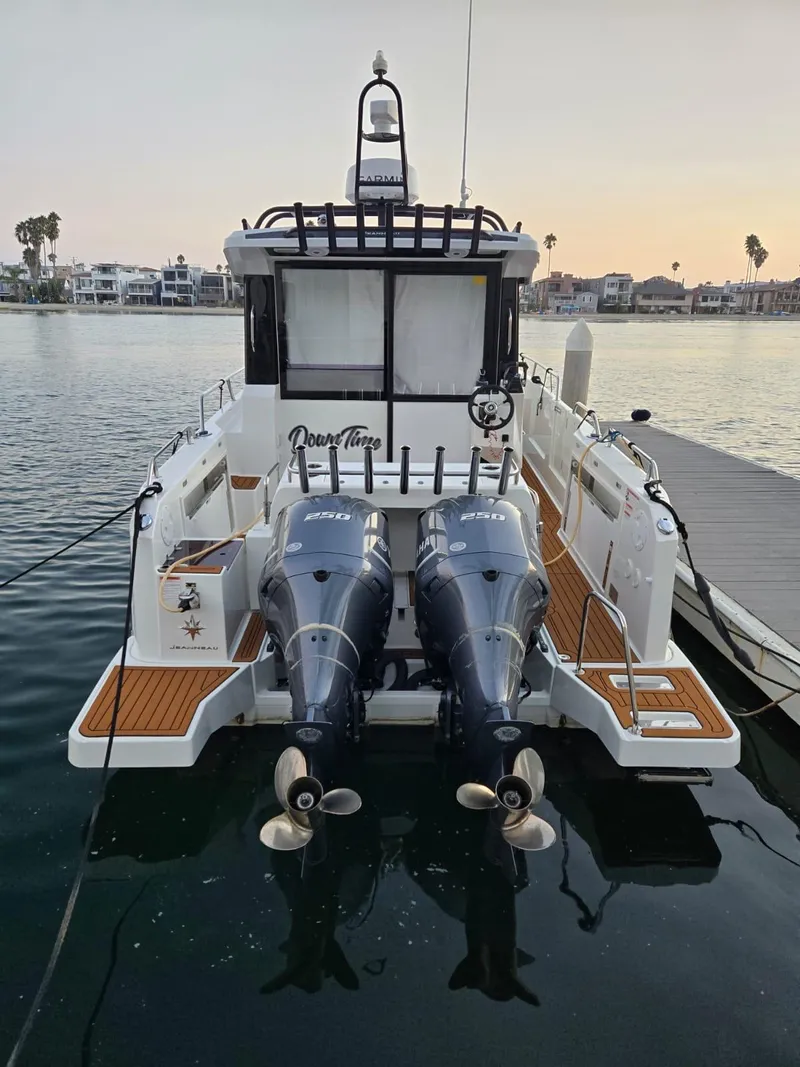 Slide: The Image of 2020 Jeanneau NC 895 Sport boat docked with dual outboard engines. - 12