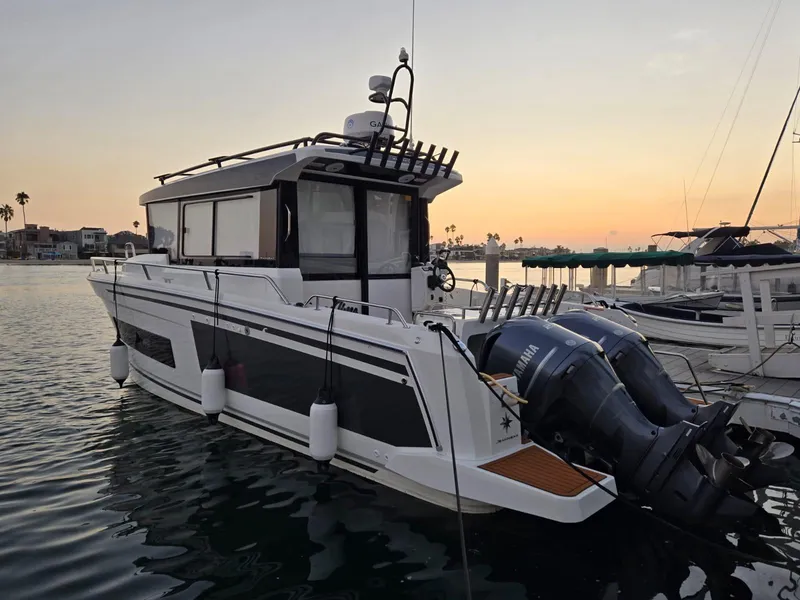 Slide: The Image of 2020 Jeanneau NC 895 Sport boat docked at sunset with dual Yamaha engines. - 14