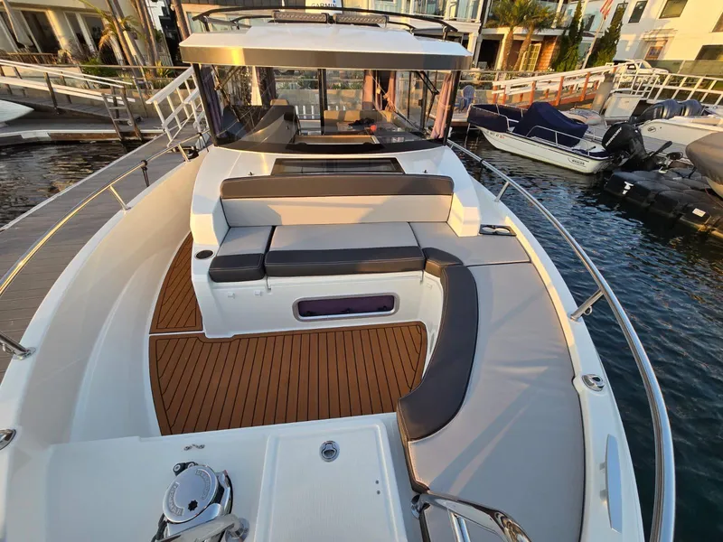 Slide: The Image of 2020 Jeanneau NC 895 Sport boat with spacious deck and seating area at marina. - 15