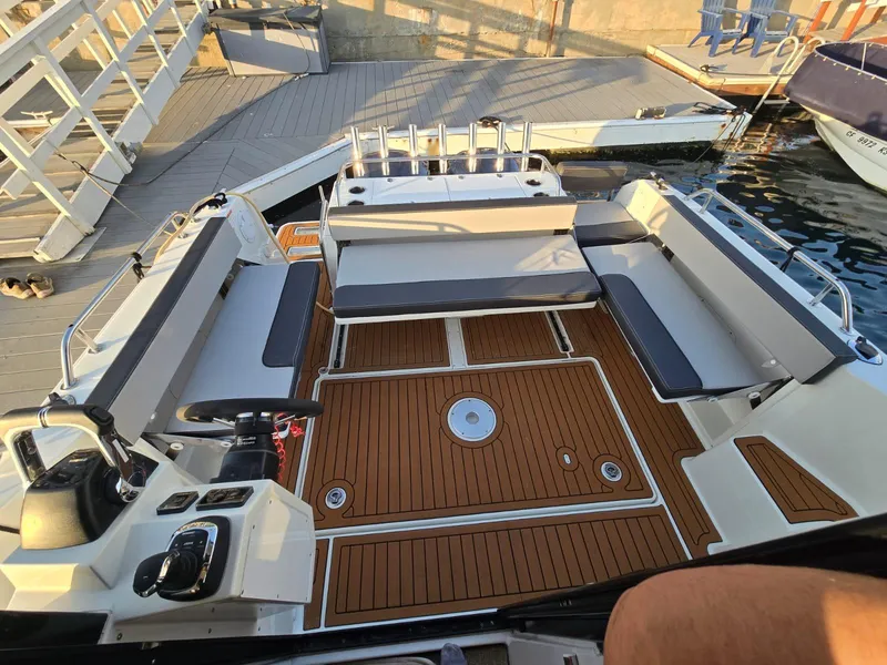 Slide: The Image of 2020 Jeanneau NC 895 Sport boat with spacious deck and seating at the marina. - 16