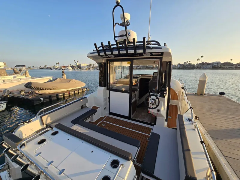 Slide: The Image of 2020 Jeanneau NC 895 Sport boat docked, showcasing spacious deck and modern design. - 19