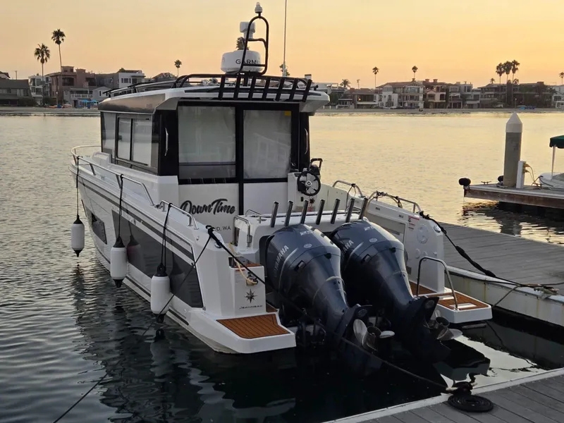 Slide: The Image of 2020 Jeanneau NC 895 Sport boat docked at sunset with dual outboard motors. - 2