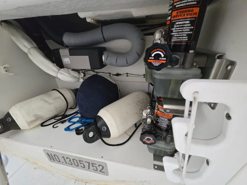 Slide: The Image of Storage compartment of 2020 Jeanneau NC 895 Sport with marine equipment and steering service valve. - 20