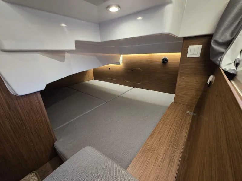Slide: The Image of 2020 Jeanneau NC 895 Sport cabin interior with modern wood finish and cozy sleeping area. - 21