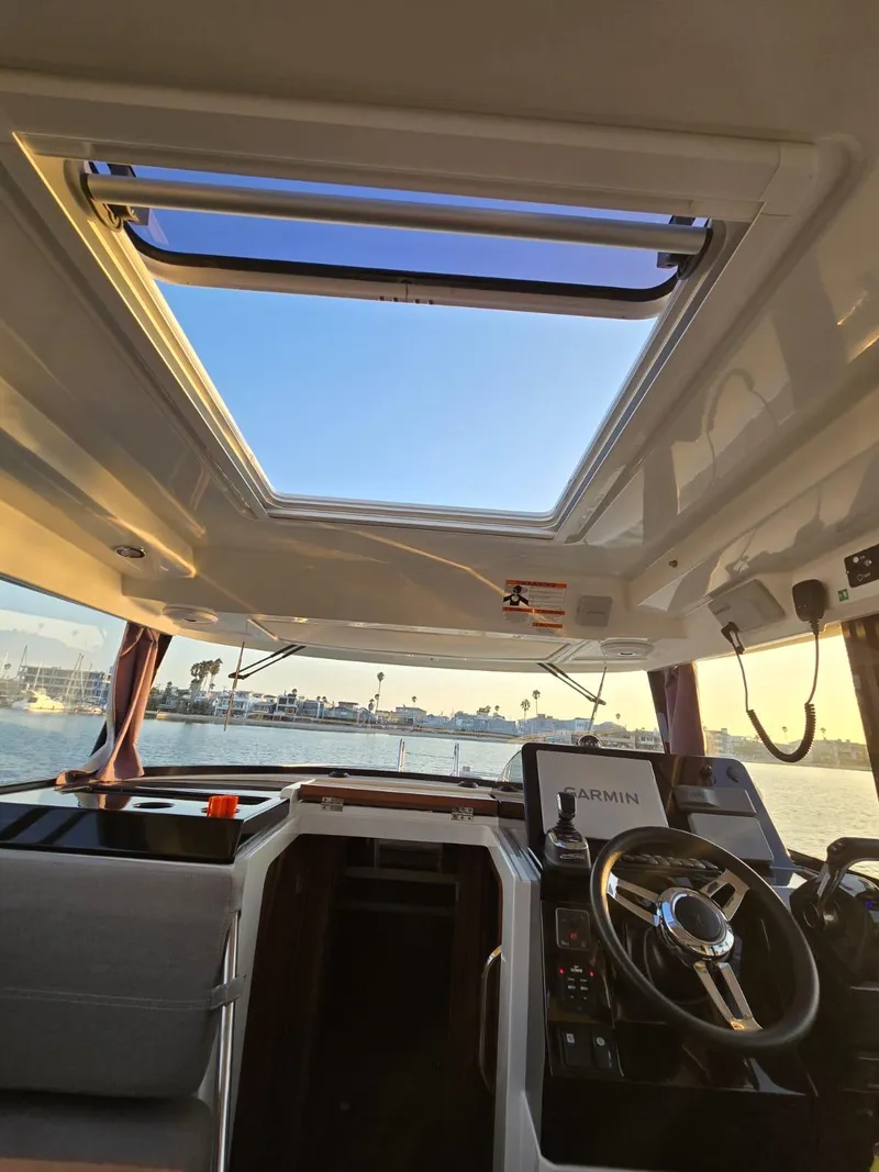 Slide: The Image of Interior view of 2020 Jeanneau NC 895 Sport boat with open sunroof and steering console. - 29