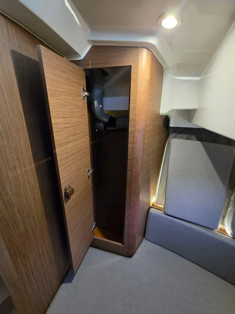 Slide: The Image of 2020 Jeanneau NC 895 Sport interior with open wooden cabinet and cozy seating area. - 32