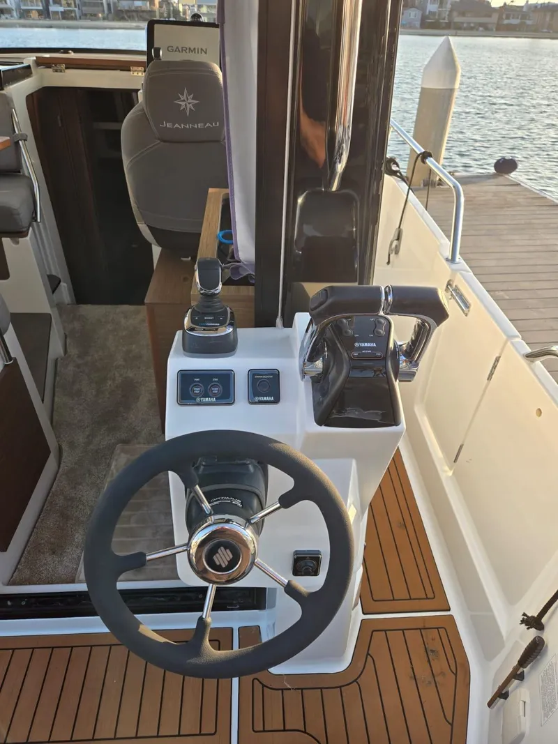 Slide: The Image of 2020 Jeanneau NC 895 Sport helm with steering wheel and controls, dockside view. - 34