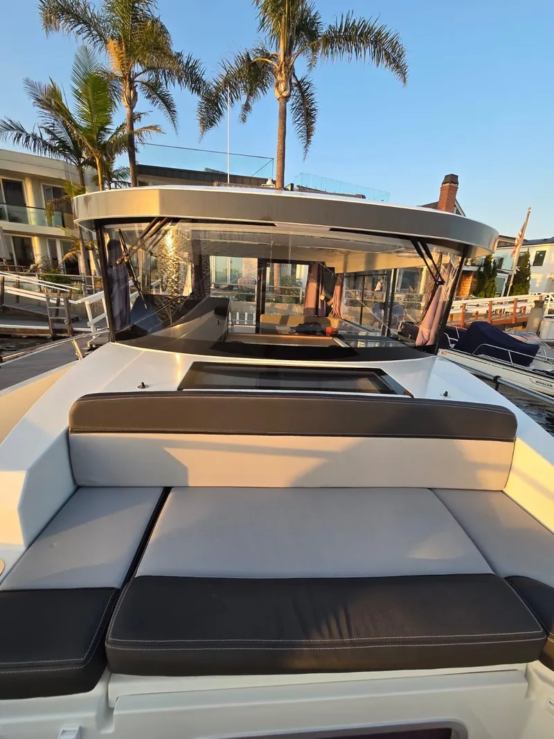 Slide: The Image of 2020 Jeanneau NC 895 Sport boat with cushioned deck, docked near palm trees. - 45