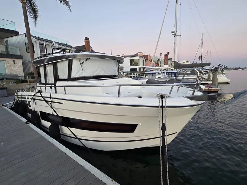 Slide: The Image of 2020 Jeanneau NC 895 Sport boat docked at a marina, showcasing sleek design and modern features. - 6
