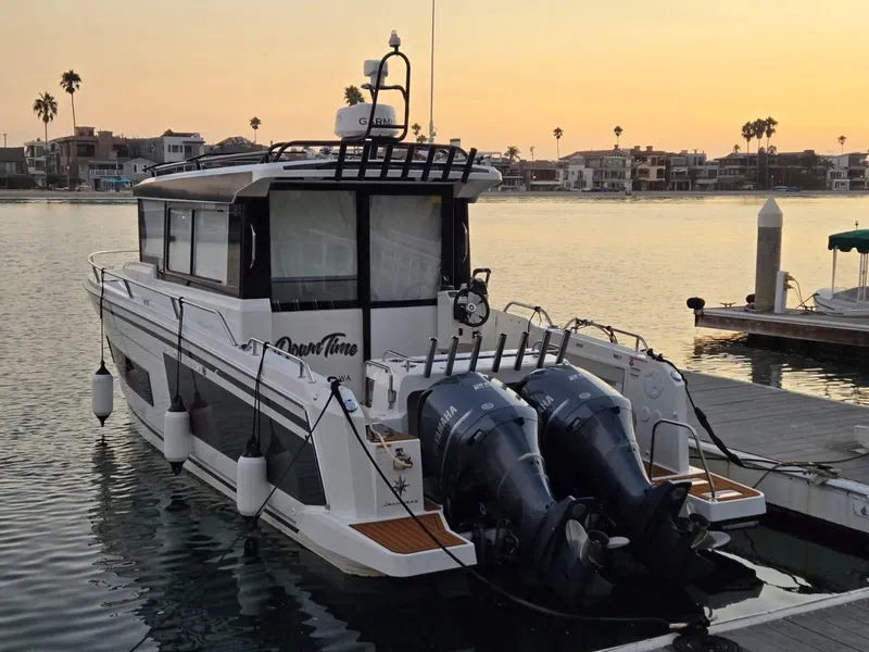 Slide: The Image of 2020 Jeanneau NC 895 Sport boat docked at sunset with dual outboard engines. - 7