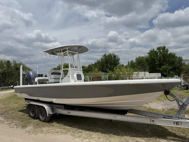 Slide: The Image of 2024 Pathfinder 2600 HPS boat on trailer, parked outdoors under cloudy sky. - 1