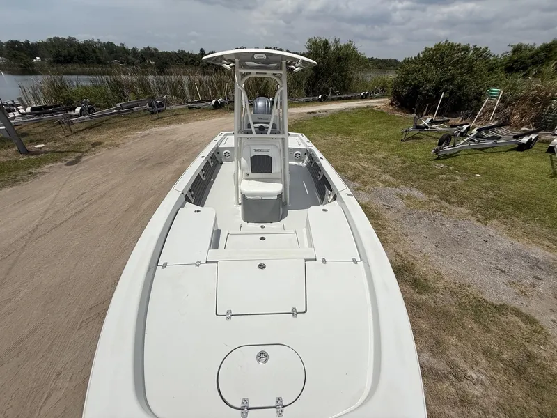 Slide: The Image of 2024 Pathfinder 2600 HPS boat on grassy shore near a lake under cloudy sky. - 13