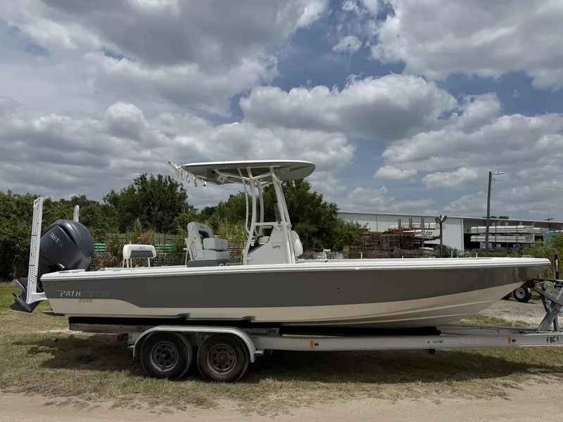 Slide: The Image of 2024 Pathfinder 2600 HPS boat on trailer under cloudy sky. - 2