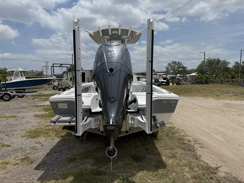 Slide: The Image of 2024 Pathfinder 2600 HPS boat with powerful outboard motor, parked outdoors under cloudy sky. - 25