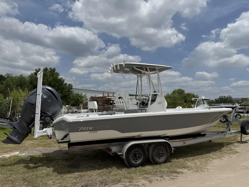 Slide: The Image of 2024 Pathfinder 2600 HPS boat on trailer, parked outdoors under cloudy sky. - 3