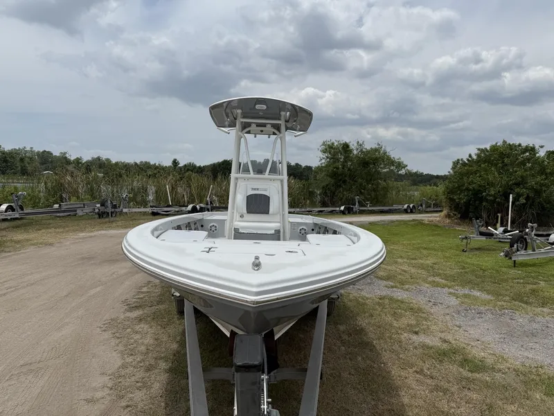 Slide: The Image of 2024 Pathfinder 2600 HPS boat on trailer, parked outdoors under cloudy sky. - 30