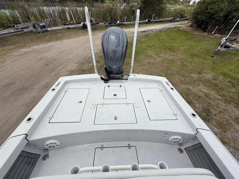 Slide: The Image of 2024 Pathfinder 2600 HPS boat deck with motor, parked on grassy area. - 34