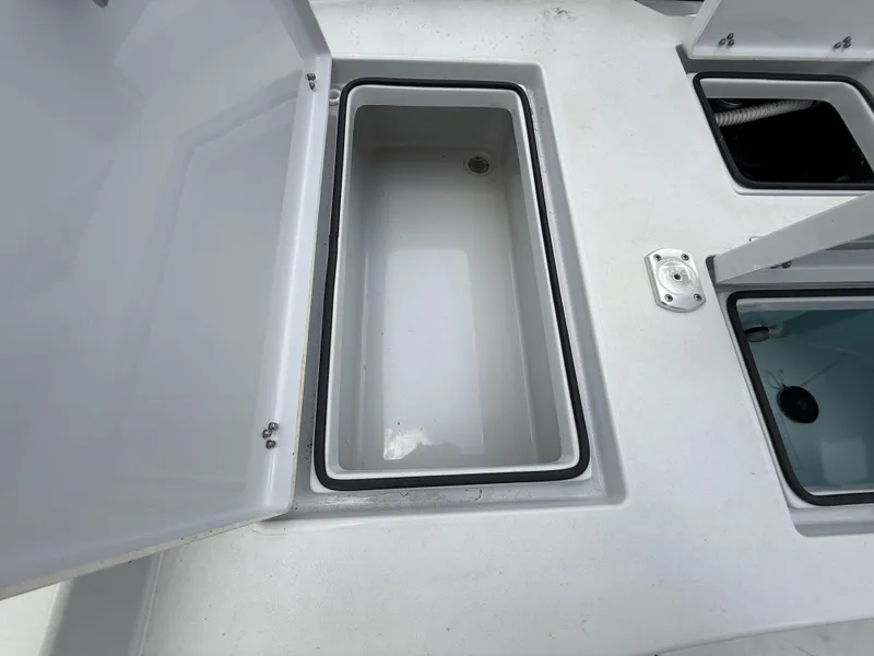 Slide: The Image of 2024 Pathfinder 2600 HPS boat storage compartments, open and empty, showcasing interior design. - 38