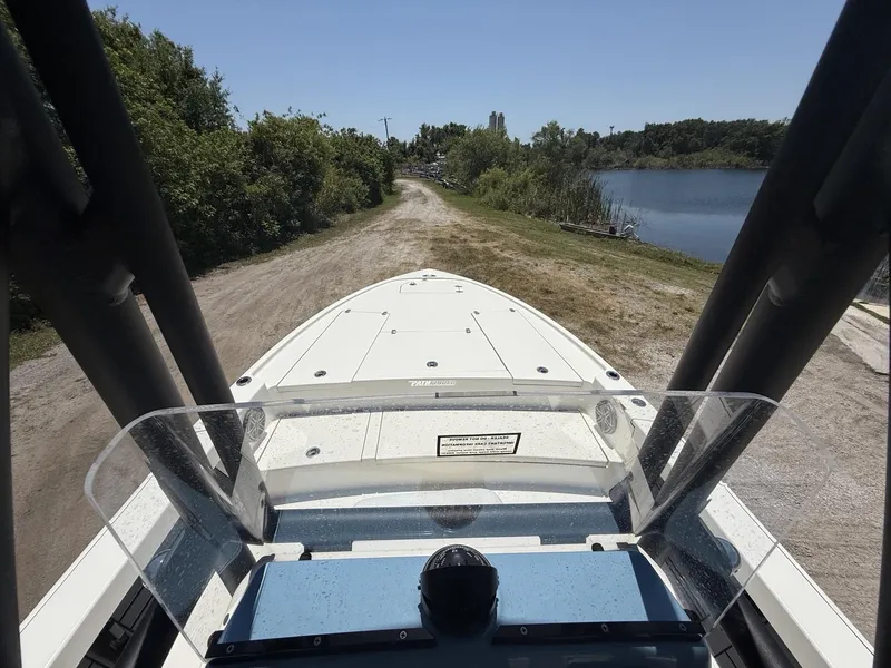 Slide: The Image of 2024 Pathfinder 2500 Hybrid boat on a dirt path near a lake, surrounded by greenery. - 10
