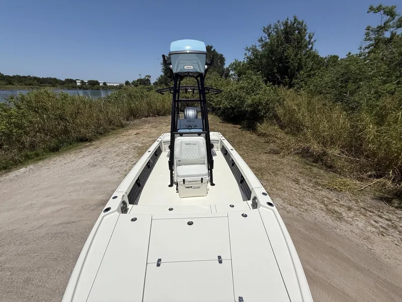 Slide: The Image of 2024 Pathfinder 2500 Hybrid boat on a sandy shore, surrounded by greenery and a clear blue sky. - 12