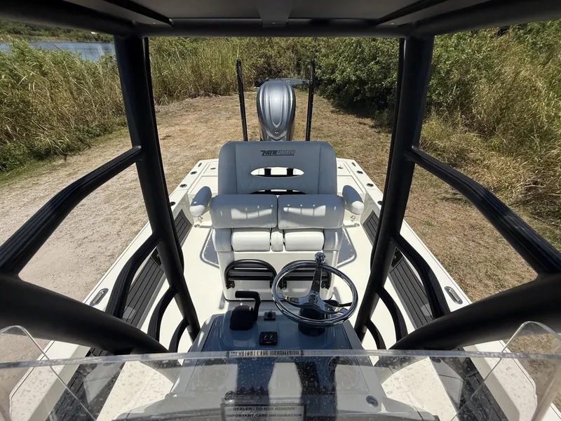 Slide: The Image of 2024 Pathfinder 2500 Hybrid boat interior with steering wheel and seating, surrounded by greenery. - 14