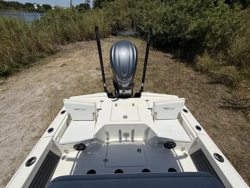 Slide: The Image of 2024 Pathfinder 2500 Hybrid boat with outboard motor, docked on grassy shore. - 15