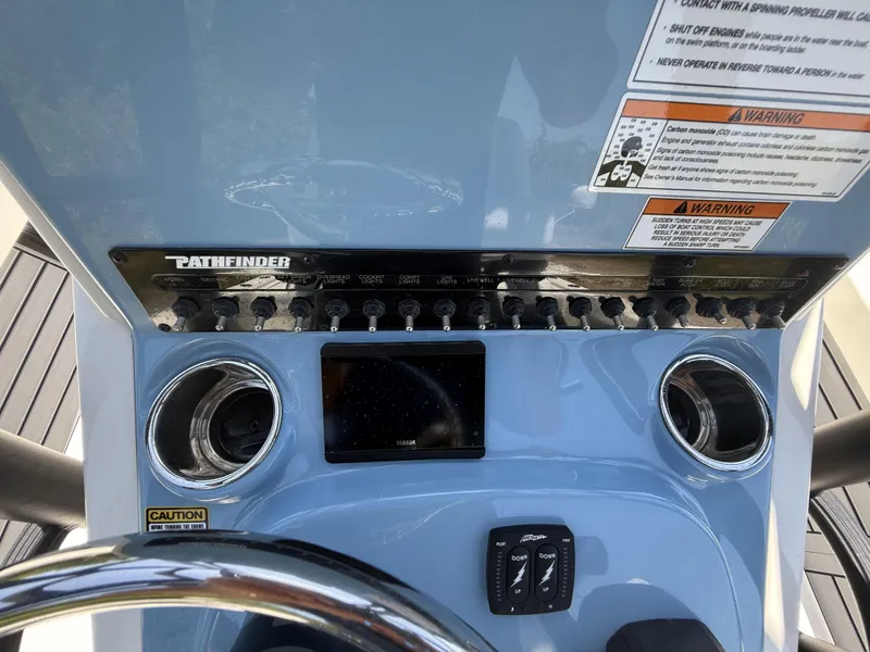 Slide: The Image of 2024 Pathfinder 2500 Hybrid boat dashboard with controls and warning labels. - 21