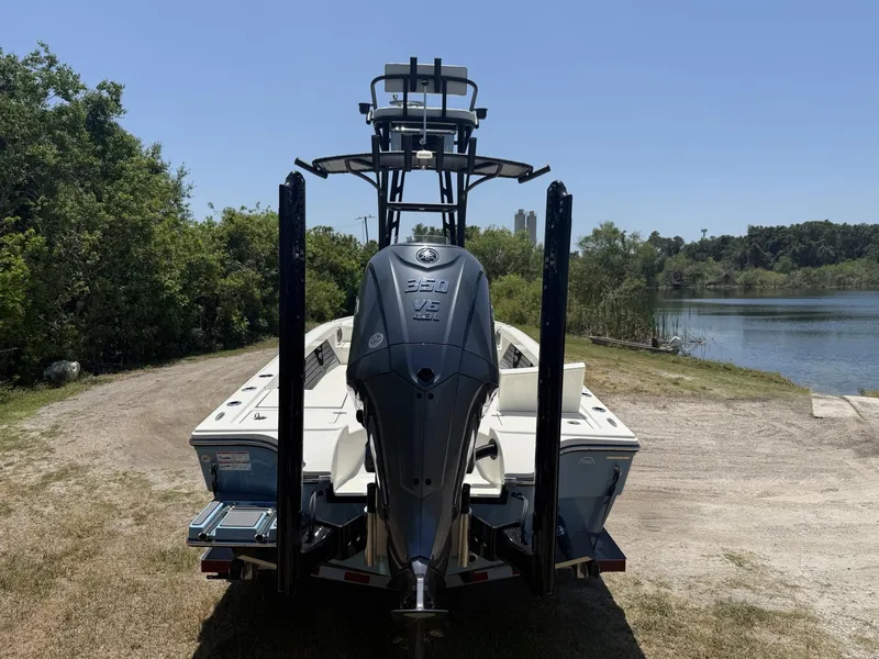 Slide: The Image of 2024 Pathfinder 2500 Hybrid boat with powerful outboard motor near a serene lake. - 28