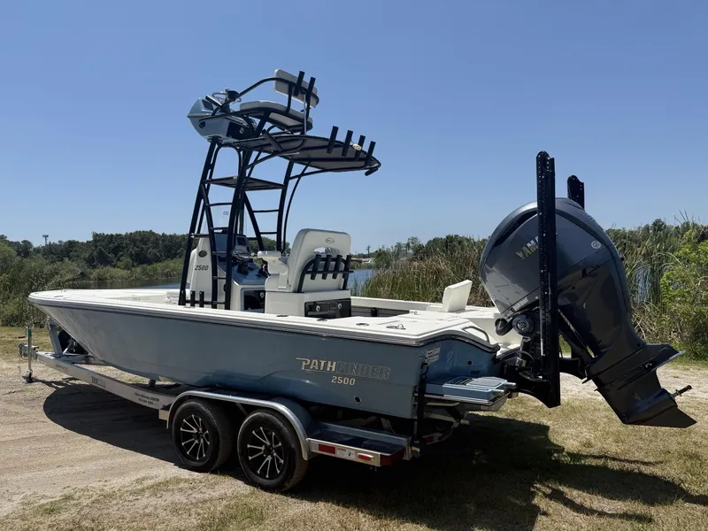 Slide: The Image of 2024 Pathfinder 2500 Hybrid boat on trailer, featuring Yamaha outboard motor, parked near a lake. - 29