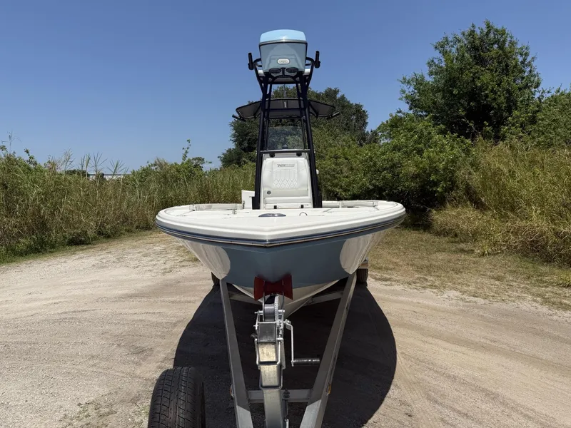 Slide: The Image of 2024 Pathfinder 2500 Hybrid boat on trailer, surrounded by greenery under clear blue sky. - 31