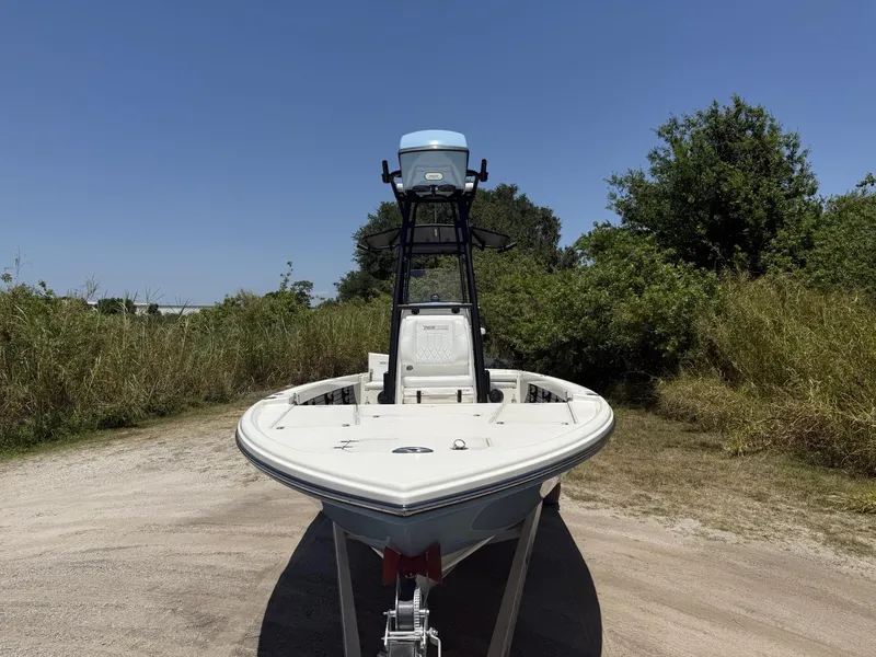 Slide: The Image of 2024 Pathfinder 2500 Hybrid boat on trailer, surrounded by greenery under clear blue sky. - 32