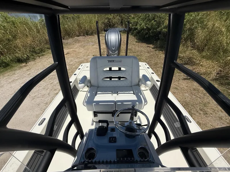 Slide: The Image of 2024 Pathfinder 2500 Hybrid boat interior with steering wheel and seating, parked on grassy terrain. - 35