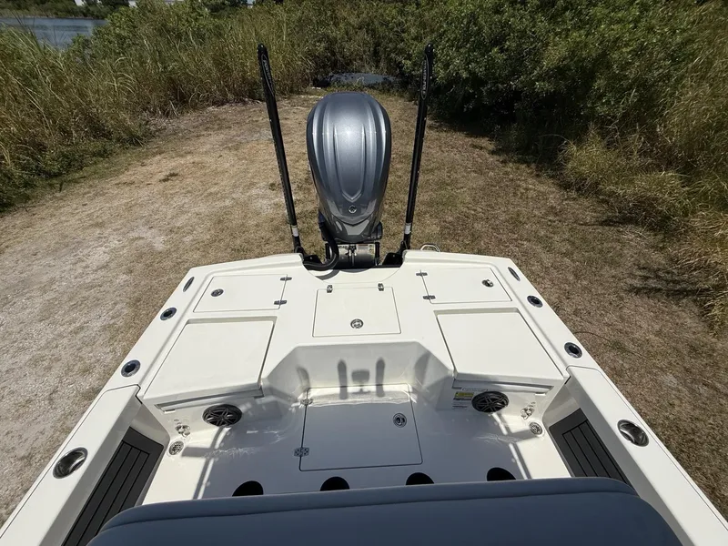 Slide: The Image of 2024 Pathfinder 2500 Hybrid boat deck with motor, surrounded by grass and water. - 36