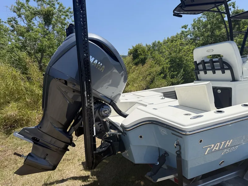 Slide: The Image of 2024 Pathfinder 2500 Hybrid boat with Yamaha outboard motor, parked on grass. - 4