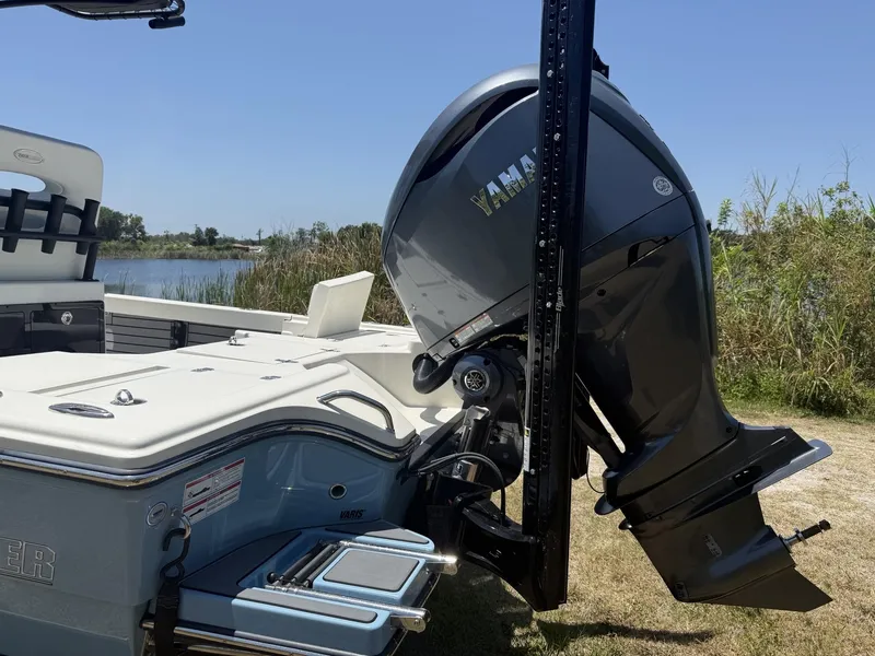 Slide: The Image of 2024 Pathfinder 2500 Hybrid boat with Yamaha outboard motor, docked near grassy shoreline. - 5