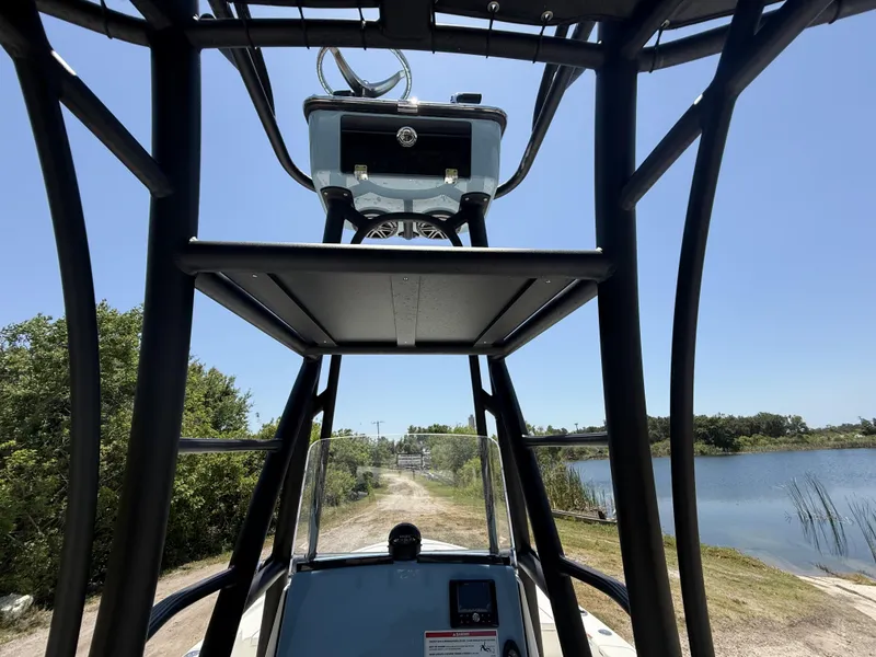 Slide: The Image of 2024 Pathfinder 2500 Hybrid boat interior with tower, near a scenic lake. - 9